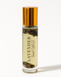 A bottle of ShadedbyShanell Essential Lavender Infused Cuticle Oil with floating lavender, capped with a gold-colored cap.