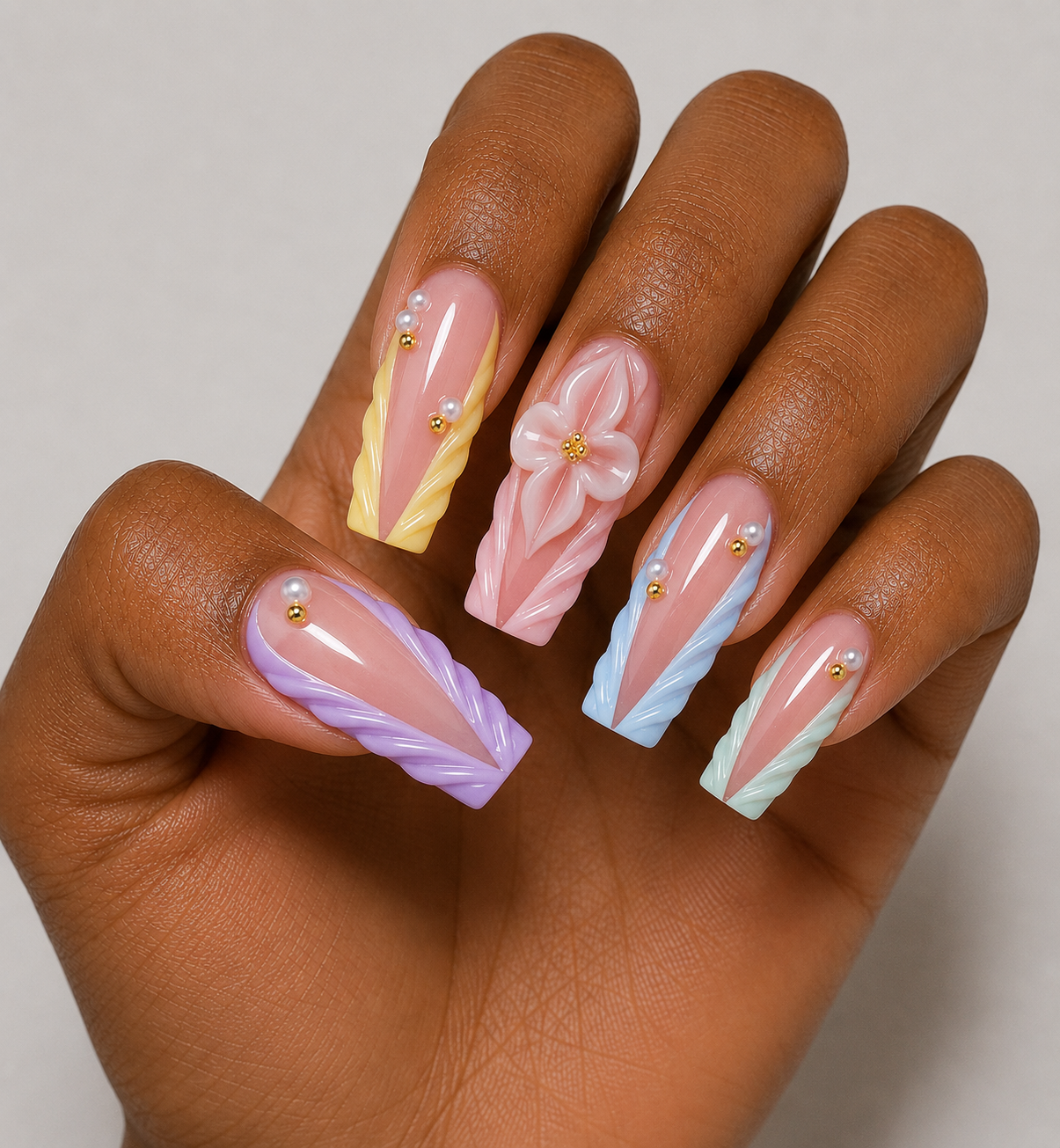 Hand with pastel nail art on a neutral background
