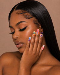 Woman with colorful abstract art press-on nails against a brown background.
