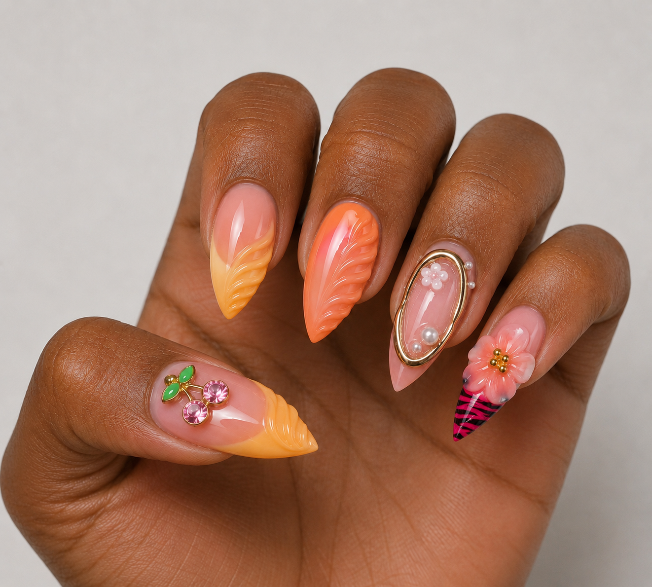 Hand with intricately designed french tip press-on nails featuring flowers, aura effect design, animal print, rhinestone, and decorative elements on a neutral background